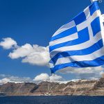 Greek flag seen against a view of Santorini island, Cyclades, Greek Islands, Greece, Europe