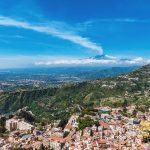 Aerial cityscape view of Taormina, located on a hillside with Et