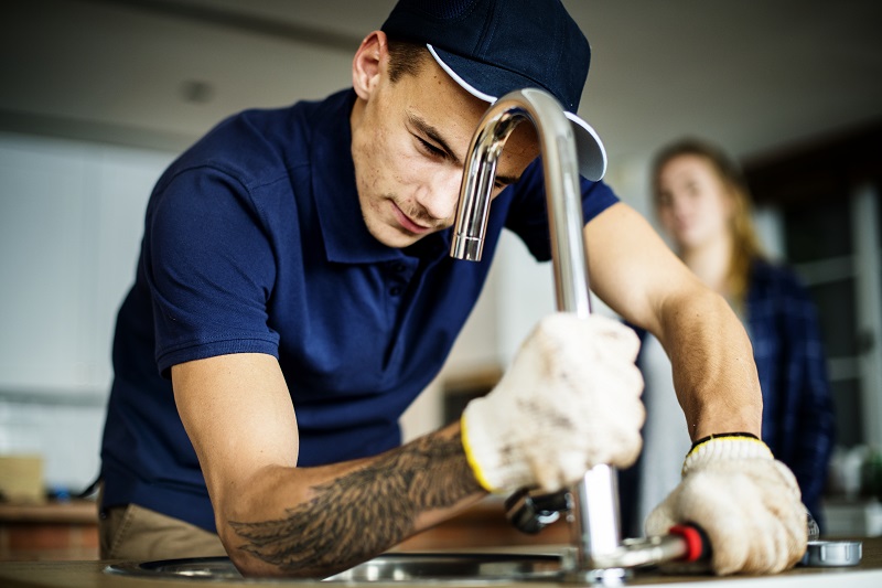 Plumber fixing kitchen sink