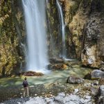 Hiker looking at waterfall, Accursed mountains, Theth, Shkoder, Albania, Europe