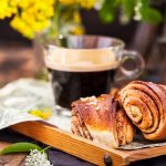 Homemade cinnamon and cardamom rolls (buns) and cup of black cof