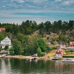 Sweden. Beautiful Red Swedish Wooden Log Cabin House On Rocky Is